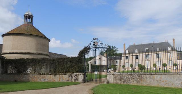 Château de Touchebredier, le colombier, la grille et le chateau principal, avec la pelouse bien tondue devant le mur de la grille