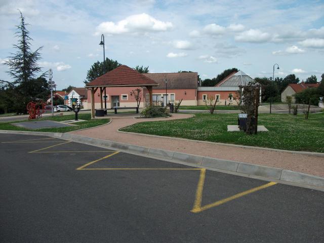 Espinasse-Vozelle : place Saint-Clément et arrêt de bus de la D 215 avec la salle annexe au deuxième plan et la mairie au troisième plan.