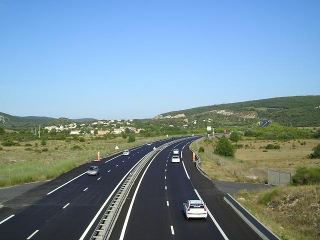 Dans l'Hérault, Saint-Paul-et-Valmalle (gauche, sud) et l'autoroute A750 (centre puis droite, nord), vue depuis l'Est et le pont de la…