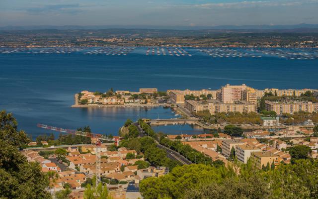 Au premier plan la partie sud-ouest du quartier de l'Ile de Thau et l'étang de Thau. Dans le fond, sur la rive opposée la commune de…