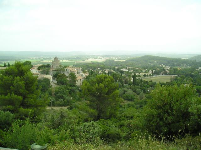 Même point de vue de Saint-Jean-de-Cuculles que cette image avec étendue alentours : extension récente du village en villas, colline Le Bosquet en allant vers la droite ; Le Triadou plus à l'arrière-plan à gauche ; au loin, les dernières lignes de collines boisées avant Montpellier.