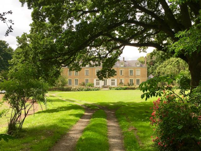Façade principale du Château de Launay masquée par les arbres.
