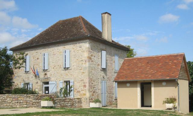 La mairie et les toilettes publiques sur la place de l'église de Béduer dans le Lot en France.