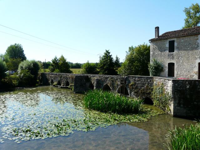Le vieux pont sur le Dropt partagé entre les communes d'Agnac (à gauche) et de La Sauvetat-du-Dropt (à droite), Lot-et-Garonne, France.