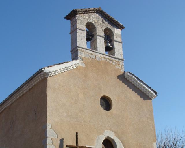 Haut de la façade de l'église de Chabestan (Hautes-Alpes). Noter la couverture en tuiles romanes avec génoise, et le petit mur-clocher…