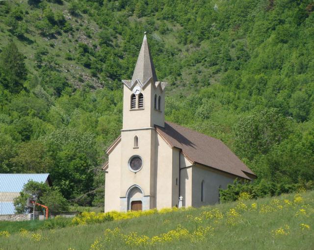 L'église d'Aspres-lès-Corps (Hautes-Alpes). Le clocher-tour carré surmonté d'une flèche octogonale fait corps avec la façade.