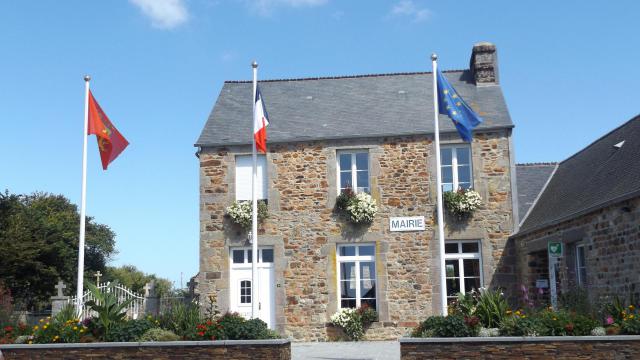 En premier plan les murets surmontés de fleurs, dans lesquels sont plantés les drapeaux de la Normandie, de la France et de l'Europe Les…