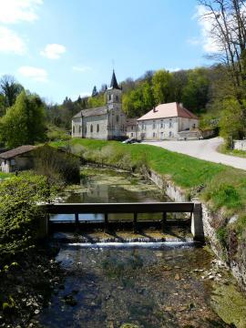 Vue du village avec la canal de dérivation du barrage du plan d'eau au premier plan.