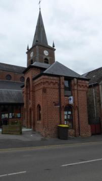 L'église Saint-Nicolas et l'Office du Tourisme d'Anor, Nord, France.