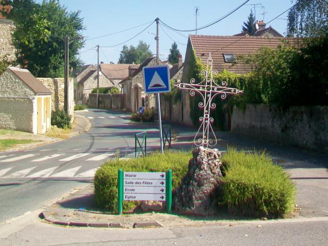L'entrée sud du village par la rue des Peupliers ; croix de chemin sur socle ancien.