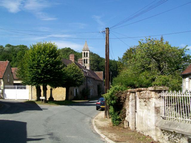 La place du village de Rhuis avec le calvaire en son centre ; au fond, l'église.