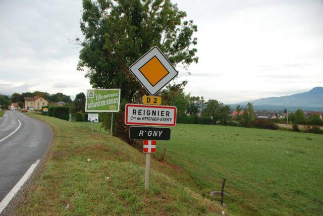 Panneau d'entrée d'agglomération en français et en arpitan à Reignier-Esery, Haute-Savoie.