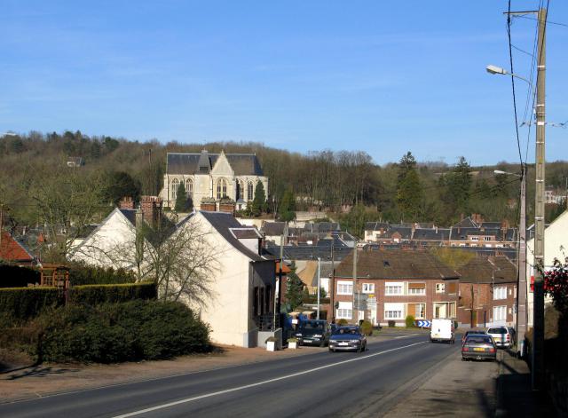 Poix-de-Picardie (Somme, France) - Descente vers le centre du bourg, depuis le Sud, par la route venant de Grandvilliers. On voit bien l'église Saint-Denis surplombant la localité et bâtie à proximité de ce qui fut le château (zone boisée à l'arrière-plan). . Lieu de la prise de vue 49° 46′ 22,1″ N, 1° 58′ 46,33″ E Voir cet endroit et d’autres images sur : OpenStreetMap - Google Earth 49.772805; 1.979535