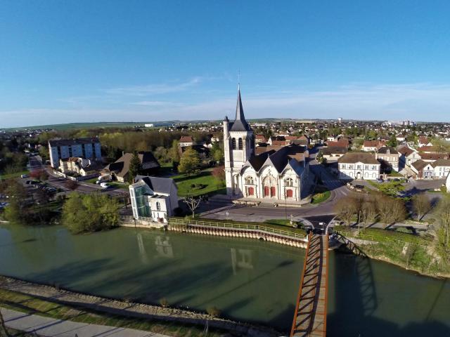 Vue aérienne de l’église Notre Dame de l'assomption - Au premier plan, la rivière Écorce" et sa passerelle.