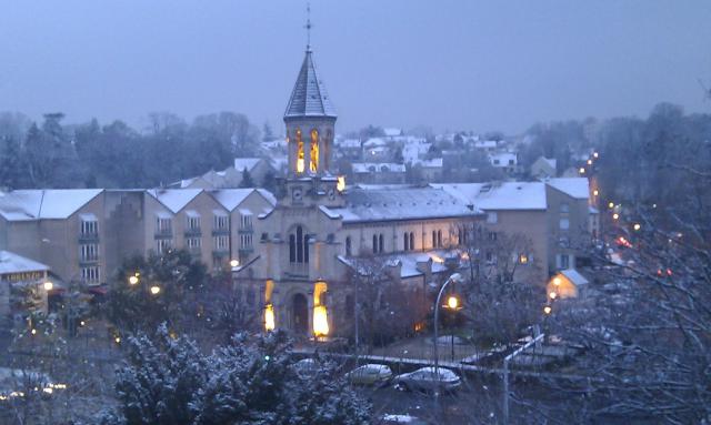 Église de Ris-Orangis sous la neige en hiver. Bâtiment illuminé par le manque de clarté de fin de journée.