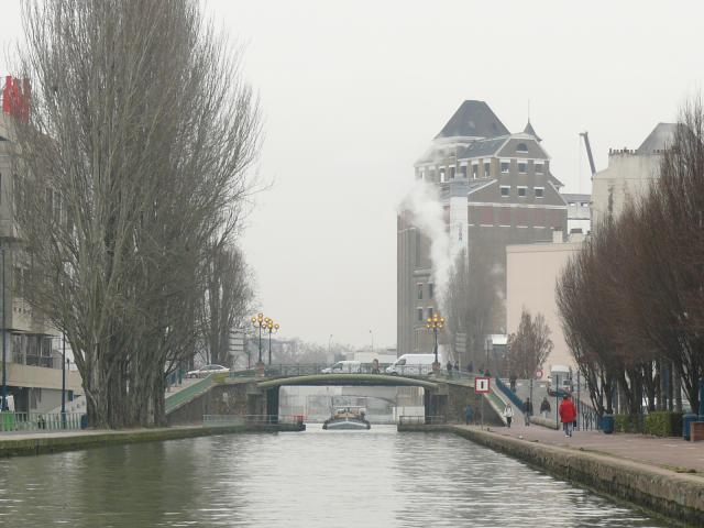 Pantin (Seine-Saint-Denis, France) : le Canal de l'Ourcq, au niveau du pont de la Mairie : une barge chargée de sable remonte le canal. A…