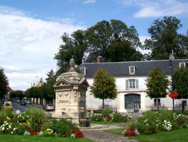 La fontaine monumentale en face de la mairie ; en arrière-plan, une maison du XVIIIe siècle.