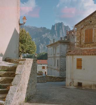 Ghisoni (Haute-Corse), une rue dans le village, avec vue sur les montagnes environnantes