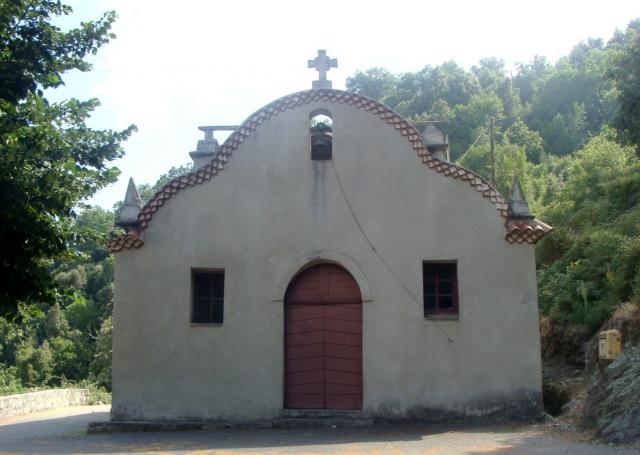 La façade de la chapelle d'Ajola. La courbe du faîte du mur de façade est originale. Le clocheton ajouré est inclus dans ce mouvement.