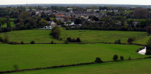 Une vue du bourg de Trévières et de la rivière Aure au premier plan.