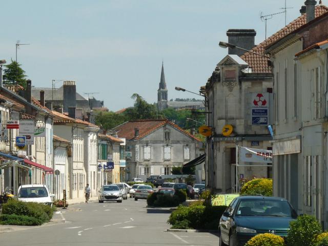 rue principale de St-Aigulin (Charente-Maritime, France); au loin le clocher de l'église de La Roche-Chalais (Dordogne).