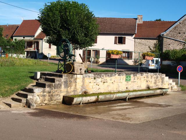 Maconge (Côte d'Or, France) ; abreuvoir & sa pompe. La vieille pompe à godets montée au-dessus d'un puits, et son abreuvoir en métal…