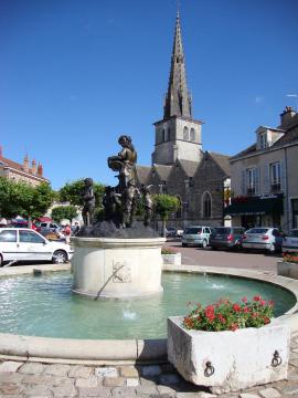 Meursault (Côte-d'Or, Bourgogne, France). Fontaine sur la place de l'Hôtel de ville. Au fond, l'église Saint-Nicolas.