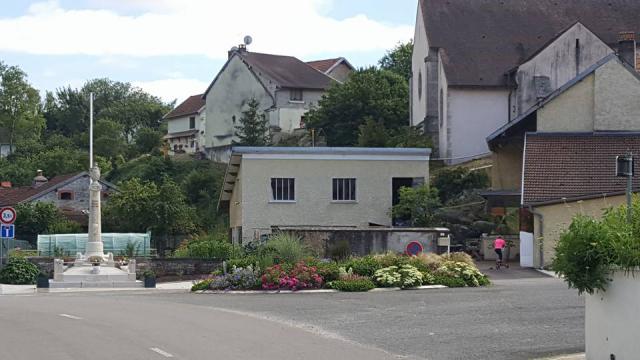 Vue sur le monument aux morts et massifs de fleurs de FONCEGRIVE