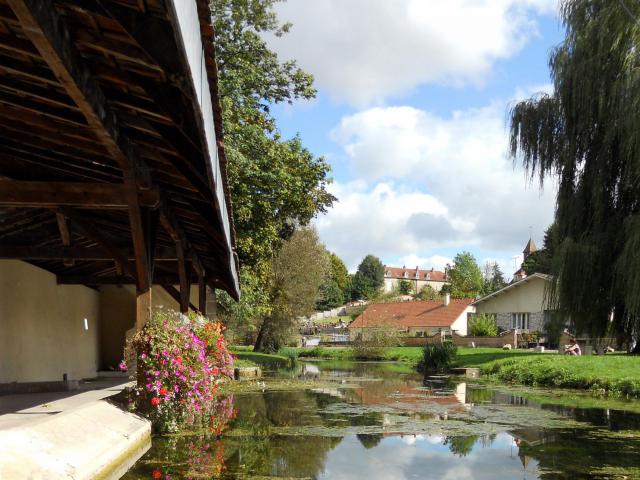 Photographie de l'Ignon : à gauche se situe le lavoir de Marcilly-sur-Tille, au fond au centre se situe le cimetière, et au fond à droite…
