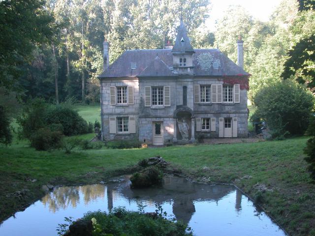 La maison donne sur une pièce d'eau avec une ile